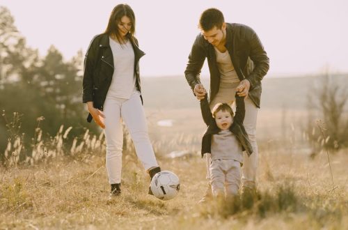 A joyful family playing soccer together in a sunlit field, showcasing love and togetherness.